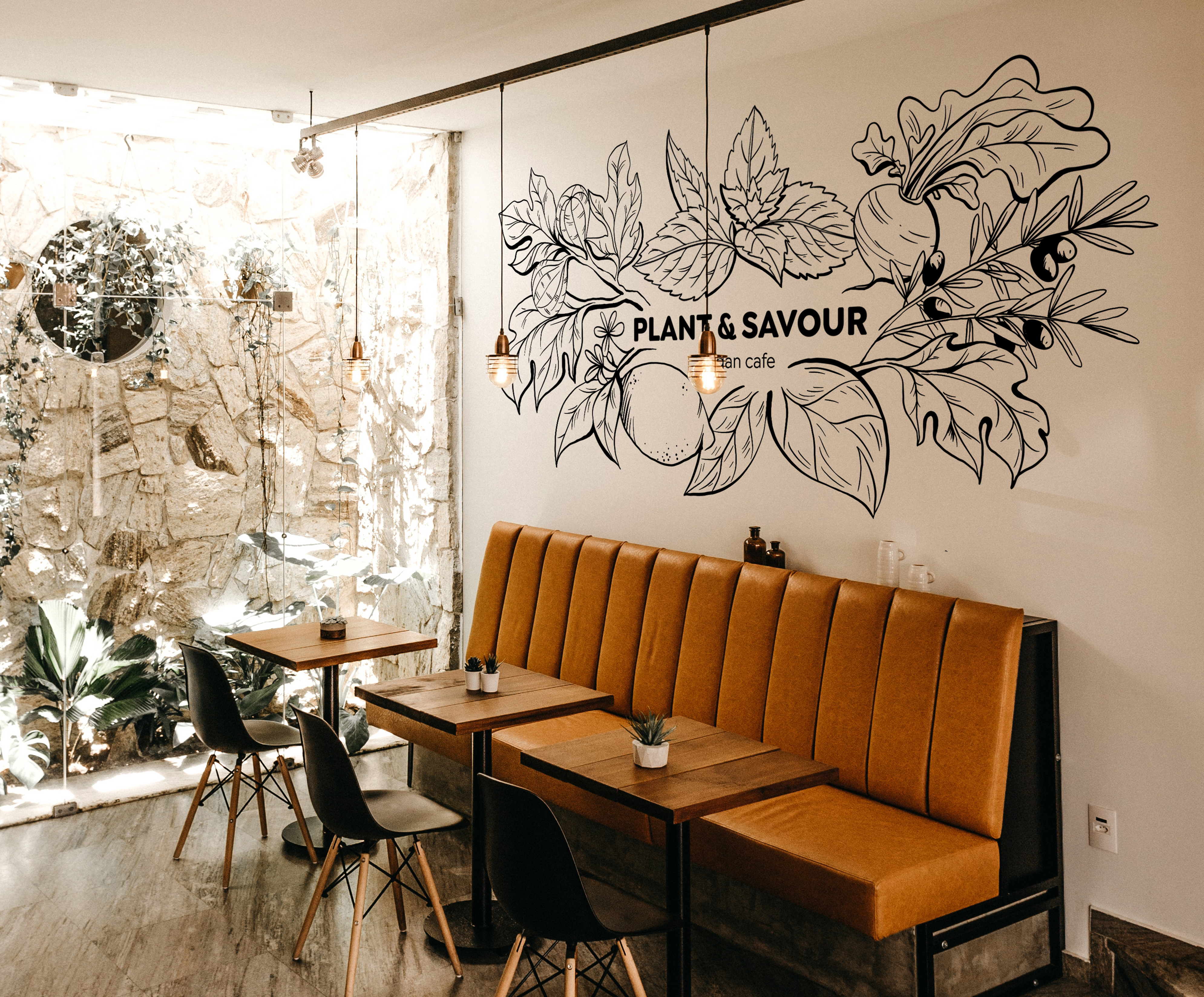 Vegan restaurant mural with hand-painted lettering and black-outline illustrations of vegetables, fruits, and leaves