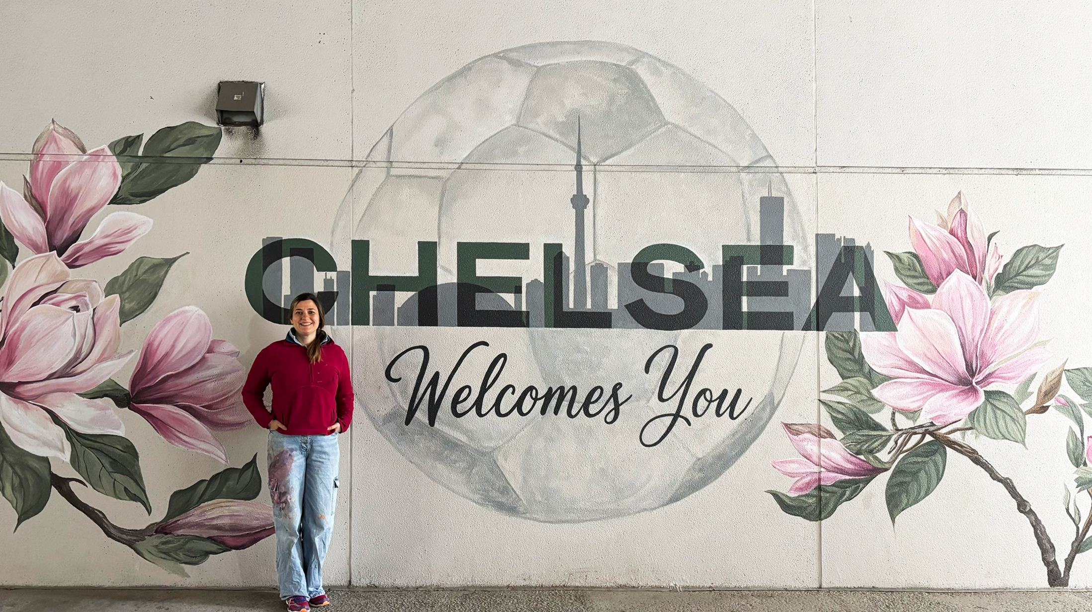 Artist painting a large-scale realistic flower mural during a workshop at Chelsea Hotel Toronto